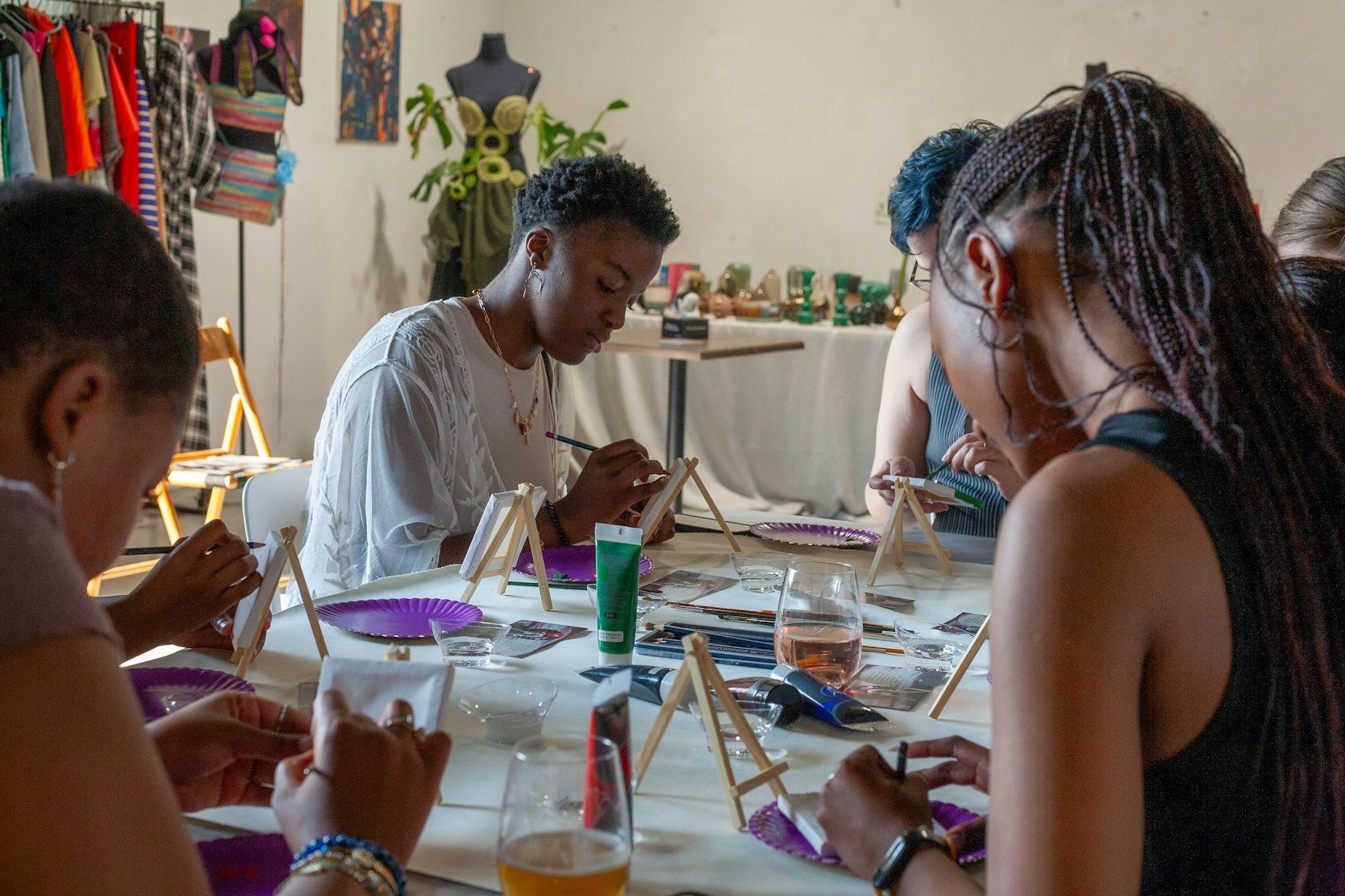 A group creating paintings around a shared art-workshop table